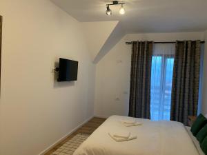 a bedroom with a bed and a flat screen tv at Carpathian Soul Maramures in Bogdan Vodă