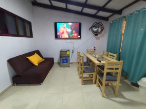 a living room with a couch and a table and a television at Casa Manaba in Baños