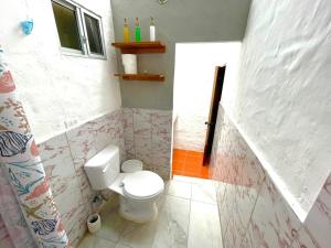 a bathroom with a white toilet in a room at BLACK&WHITE -Dis Dihai- in Puerto Ayora +4 photos