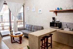 a kitchen and living room with a couch and a table at La Familia Casa and Suites in Holbox Island