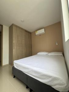 a bedroom with a large bed with a white bedsheet at Barranquilla Prime Apartment in Barranquilla
