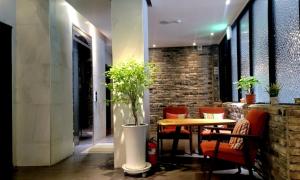 a dining room with a table and chairs and a brick wall at Jinhae Pasta Hotel in Changwon