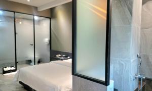 a bedroom with a bed and a glass shower at Jinhae Pasta Hotel in Changwon +15 photos