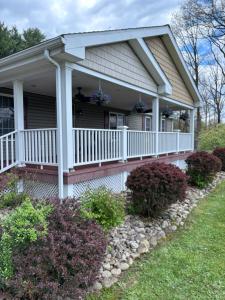 a house with a porch with flowers on it at 15 off Summer Special - Wifi - Pet Friendly in Sigel