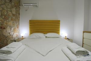 a bedroom with a bed with towels on it at Pigeon Cave Apartments in Ksamil