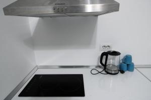 a kitchen counter with a stove top with a sink at Pigeon Cave Apartments in Ksamil