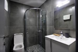a bathroom with a shower and a sink and a toilet at Pigeon Cave Apartments in Ksamil +38 photos