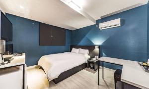 a bedroom with a bed and a blue wall at Chuncheon Hotel View in Chuncheon