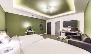 a bedroom with a bed and a couch and a tv at Chuncheon Hotel View in Chuncheon +16 photos