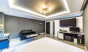 a bedroom with a bed and a tv and a couch at Chuncheon Hotel View in Chuncheon