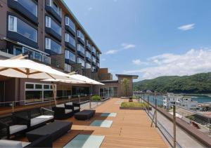 a building with benches and umbrellas on a deck at Sun Urashima Yuki no Sato in Toba
