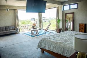 a bedroom with a bed and a large window at La Familia Casa and Suites in Holbox Island +86 photos