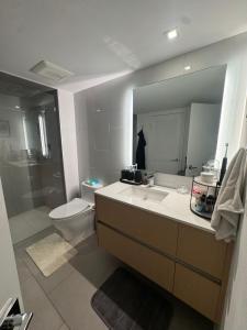 a bathroom with a sink and a toilet and a mirror at Luxury Loft 1BR Steps Away from Santa Monica Pier in Los Angeles
