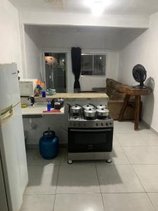a kitchen with a stove with pots and pans on it at Kitnet céu e mar in Saquarema +4 photos