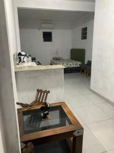 a room with a glass table with a wooden chair at Kitnet céu e mar in Saquarema