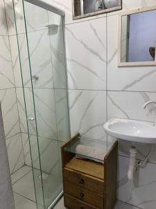 a bathroom with a glass shower and a sink at Kitnet céu e mar in Saquarema