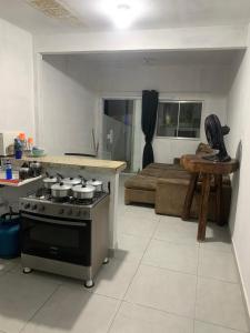 a kitchen with a stove and a kitchen with a bed at Kitnet céu e mar in Saquarema
