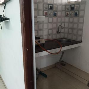 a kitchen with a sink and a hose at Shifa Home Near Apollo Sankara Nethralaya Main Hospital in Chennai