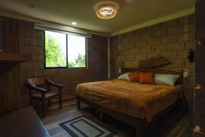 ein Schlafzimmer mit einem Bett, einem Fenster und einem Stuhl in der Unterkunft Hotel Jabal Inn in Tixmucuy + 94 Fotos