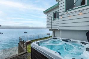 a hot tub on the side of a house overlooking the water at Oyster Oasis in Tahuya