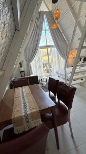 a bedroom with a table and chairs and a large window at Cabin Corazon in Coron