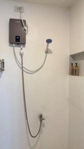 a shower with a hose attached to a wall at Cabin Corazon in Coron