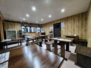 a dining room with wooden tables and benches at 五島宿Seina in Goto