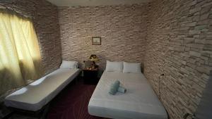 two beds in a room with a brick wall at Magic View in Bine el Ouidane