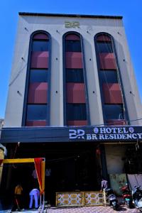a hotel building with people standing in front of it at Hotel B R Residency in Bikaner