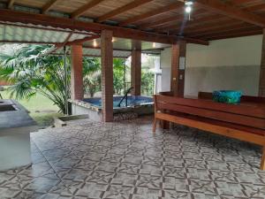 a patio with a bench and a hot tub at Riverside Oasis Cabin with A C in Guápiles