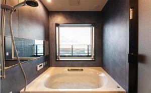 a bath tub in a bathroom with a window at Tabinoteitaku Y-beach in Tsuruoka +27 photos