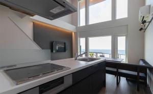 a kitchen with a sink and a large window at Tabinoteitaku Y-beach in Tsuruoka