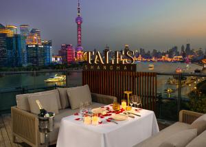 a table on a balcony with a view of the city at Banyan Tree Shanghai On the Bund in Shanghai