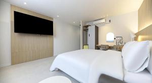 a bedroom with a large bed and a flat screen tv at 프라잇베리 호텔 in Chinhae