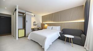 a bedroom with a large white bed and a couch at 프라잇베리 호텔 in Chinhae