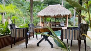 a patio with a table and chairs and a pavilion at Casa Siwa in Cahuita