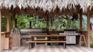 an outdoor kitchen with a table and a stove at Casa Siwa in Cahuita