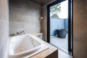a bathroom with a bath tub and a window at KomoreNest伊豆熱川 in Higashiizu +75 photos