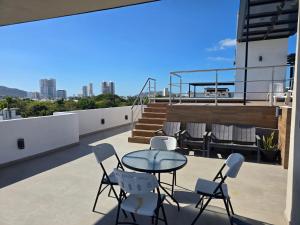 a patio with a table and chairs on a roof at hermoso departamento totalmente equipado ,céntrico, aberca, elevador , estacionamiento privado in Mazatlán