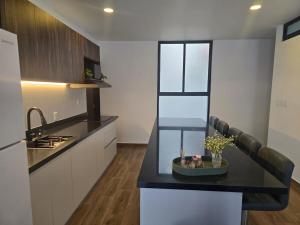 a kitchen with a black counter top and a sink at hermoso departamento totalmente equipado ,céntrico, aberca, elevador , estacionamiento privado in Mazatlán