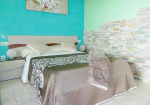 sypialnia z łóżkiem i ścianą z cegły w obiekcie Luxury Apartment Balcon de Jandía w mieście Morro del Jable