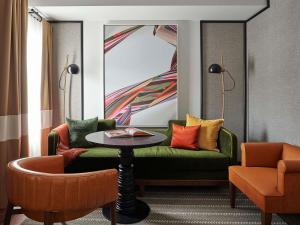 a living room with a green couch and a table at 21c Museum Hotel St Louis in Saint Louis
