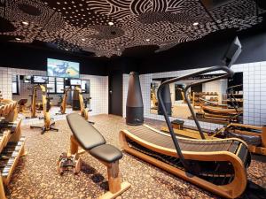 a gym with treadmills and ellipticals in a room at Mama Shelter Rennes in Rennes