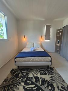 a bedroom with a bed and a rug at Appartement Butterfly in Ducos