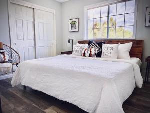 a bedroom with a large white bed with pillows at Sunset Site Boulder Bliss HotTub by Casa Oso in Ahwahnee