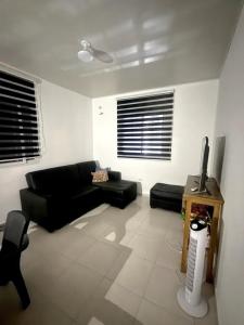 a living room with a black couch and a tv at Villa Rosita in San Carlos
