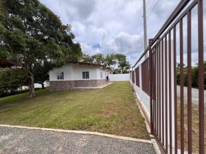 a building with a fence next to a grass yard at Villa Rosita in San Carlos