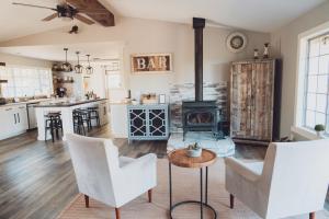 a living room with white chairs and a fireplace at Sunset Site Boulder Bliss HotTub by Casa Oso in Ahwahnee