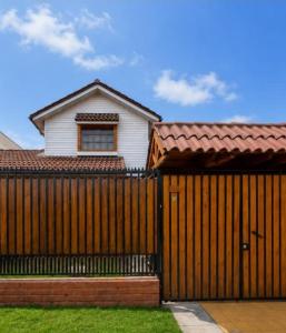 a wooden fence in front of a house at Estrella rooms La Florida in Santiago