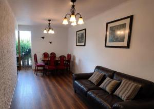 a living room with a couch and a table with chairs at Estrella rooms La Florida in Santiago
